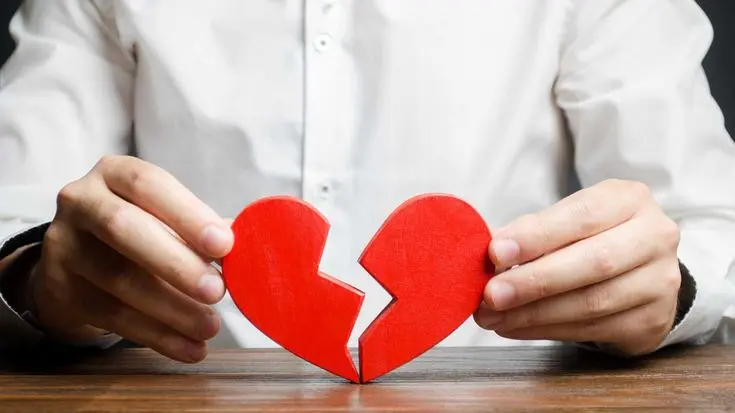 Manos sosteniendo un corazón de madera roto por la mitad, símbolo del vínculo que se busca sanar