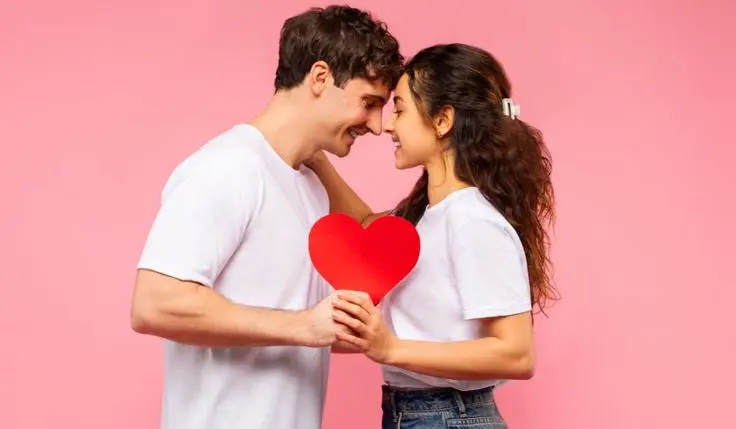 Pareja sosteniendo un corazón de papel, símbolo del vínculo que se busca fortalecer